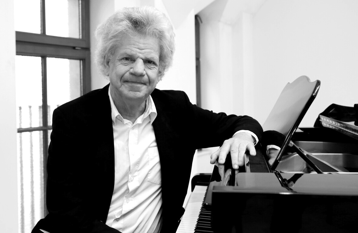 Portrait of the composer and musician Henrik Sande, sitting at a piano